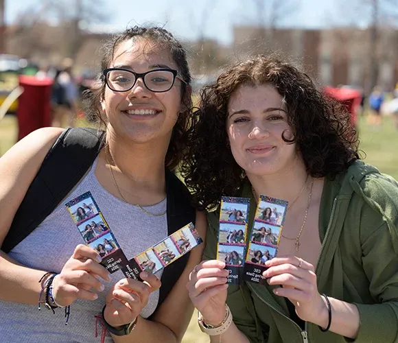 Two students showing photographs of themselves